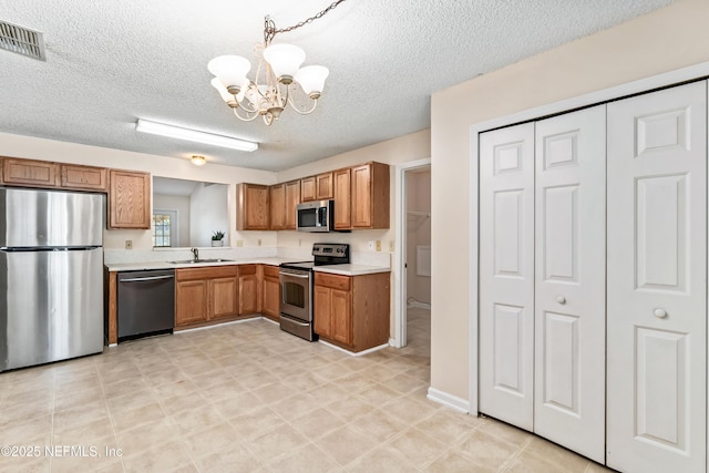11326 Hendon Dr, Jacksonville, FL 32246 - kitchen with a notable chandelier, light countertops, a sink, appliances with stainless steel finishes, and visible vents