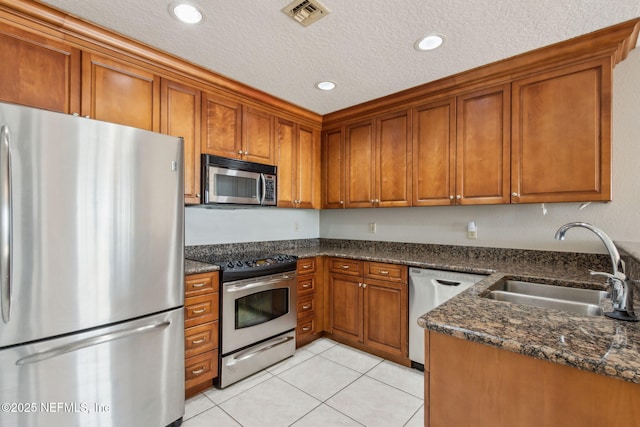 kitchen featuring visible vents, a sink, brown cabinetry, and appliances with stainless steel finishes