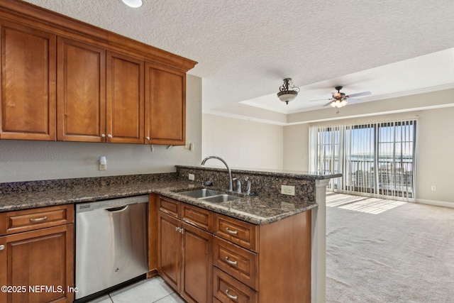 kitchen with a sink, dishwasher, a ceiling fan, a peninsula, and brown cabinetry