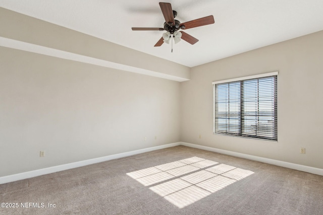 spare room with baseboards, ceiling fan, and light carpet