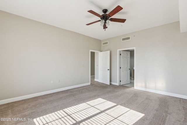unfurnished bedroom featuring a ceiling fan, baseboards, light colored carpet, and visible vents