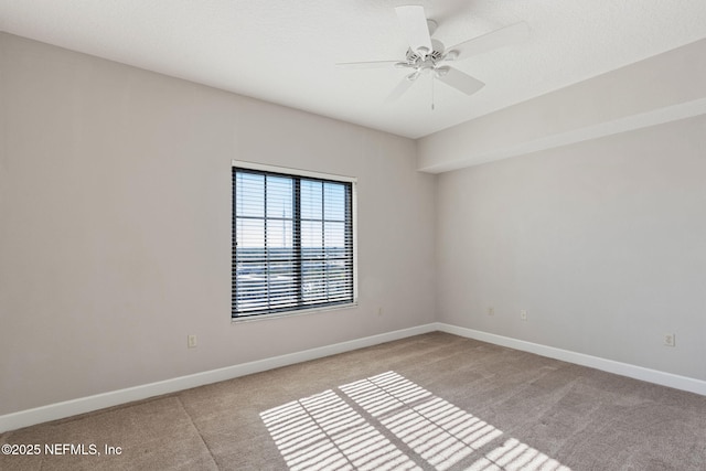 empty room featuring light carpet, baseboards, and ceiling fan