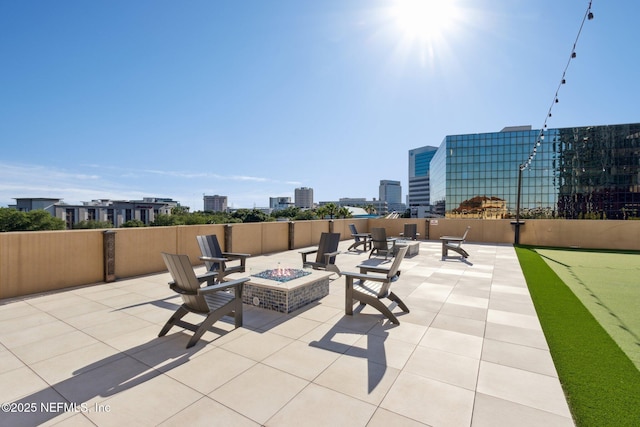 view of patio / terrace featuring an outdoor fire pit and a city view