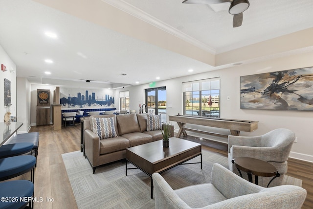 living room with a ceiling fan, light wood-type flooring, recessed lighting, baseboards, and ornamental molding