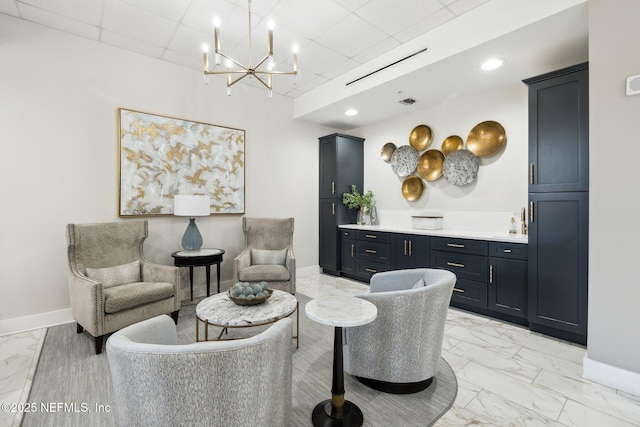 living room with marble finish floor, baseboards, a chandelier, and a paneled ceiling