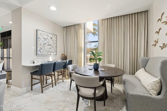 dining space with baseboards, marble finish floor, and recessed lighting