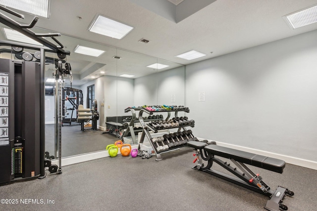 exercise room with baseboards and visible vents