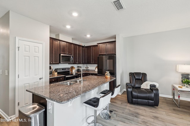 7802 Merchants Way, Jacksonville, FL 32222 - kitchen with a sink, a kitchen bar, stainless steel appliances, visible vents, and dark brown cabinets