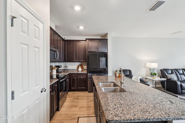 7802 Merchants Way, Jacksonville, FL 32222 - kitchen with black electric range oven, stainless steel microwave, a center island with sink, a sink, and visible vents