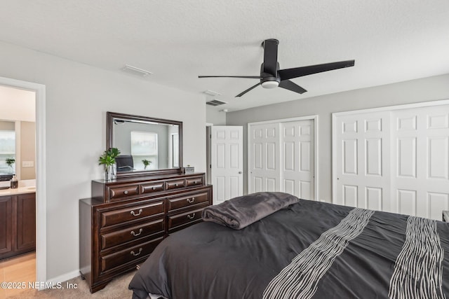 7802 Merchants Way, Jacksonville, FL 32222 - bedroom with two closets, baseboards, visible vents, light carpet, and ceiling fan