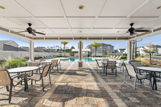 7802 Merchants Way, Jacksonville, FL 32222 - view of patio with fence, a community pool, outdoor dining area, a ceiling fan, and a residential view