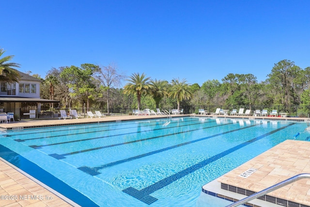 pool with a patio area and fence