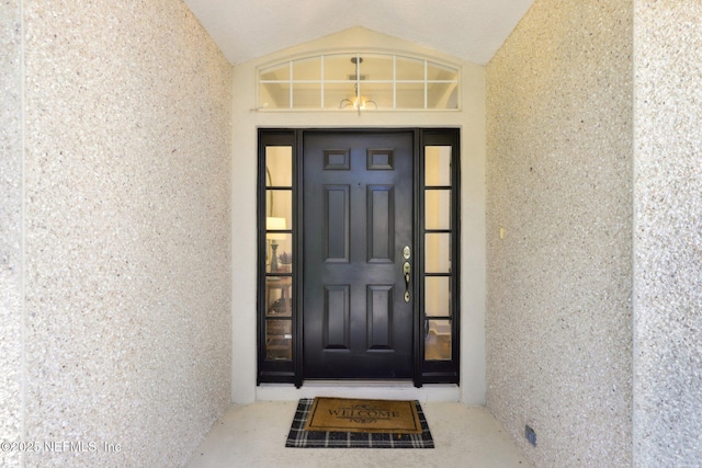 entrance to property featuring stucco siding