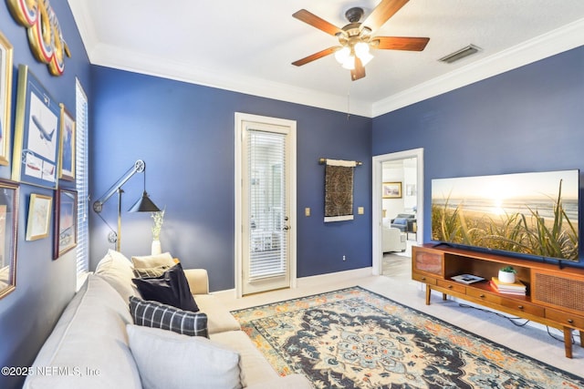 carpeted living room with baseboards, ceiling fan, visible vents, and ornamental molding