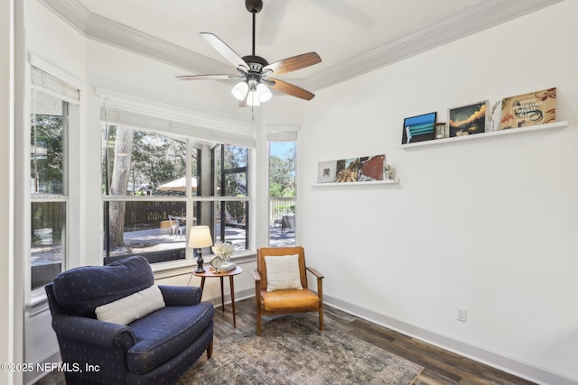sitting room with wood finished floors, ornamental molding, and a healthy amount of sunlight