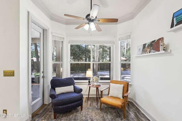 sitting room with a ceiling fan, ornamental molding, and wood finished floors