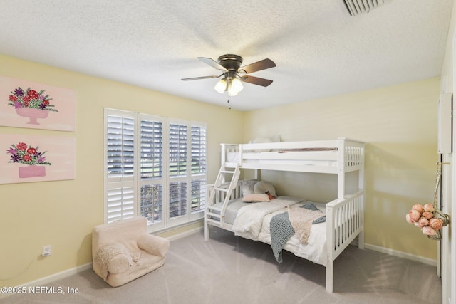 bedroom with carpet floors, a ceiling fan, a textured ceiling, baseboards, and visible vents