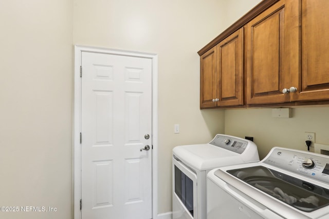 clothes washing area featuring washer and clothes dryer and cabinet space
