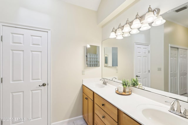 bathroom featuring double vanity, visible vents, baseboards, and a sink