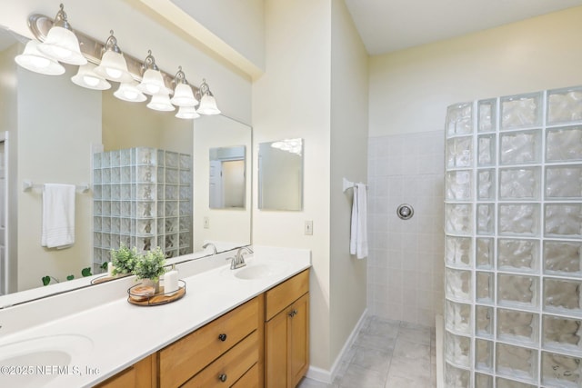 bathroom with double vanity, tile patterned floors, a sink, and walk in shower