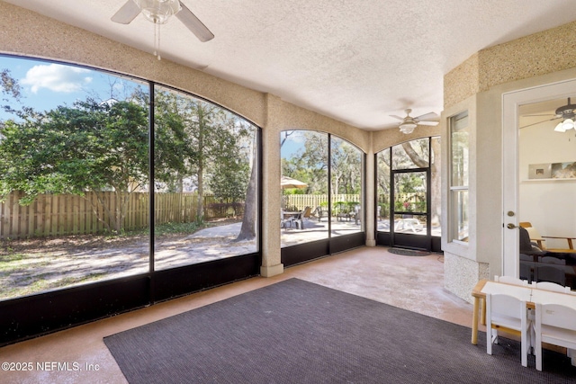 unfurnished sunroom with a textured ceiling and ceiling fan