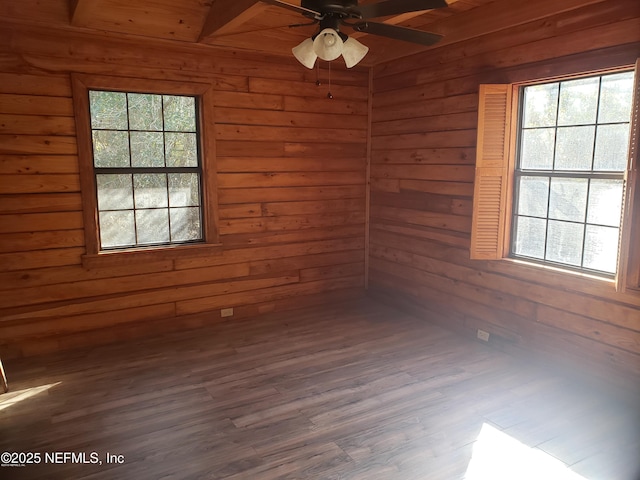spare room with plenty of natural light, wood walls, and ceiling fan