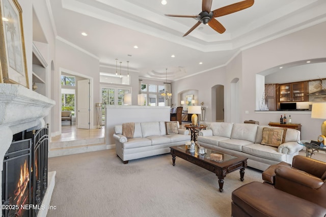 1193 Queens Harbor Blvd, Jacksonville, FL 32225 - living room featuring a ceiling fan, a warm lit fireplace, arched walkways, and ornamental molding