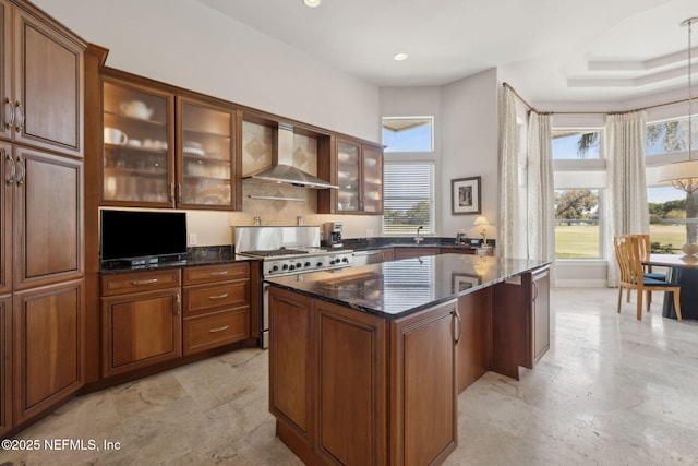 1193 Queens Harbor Blvd, Jacksonville, FL 32225 - kitchen featuring brown cabinets, dark stone counters, wall chimney exhaust hood, a kitchen island, and stainless steel range