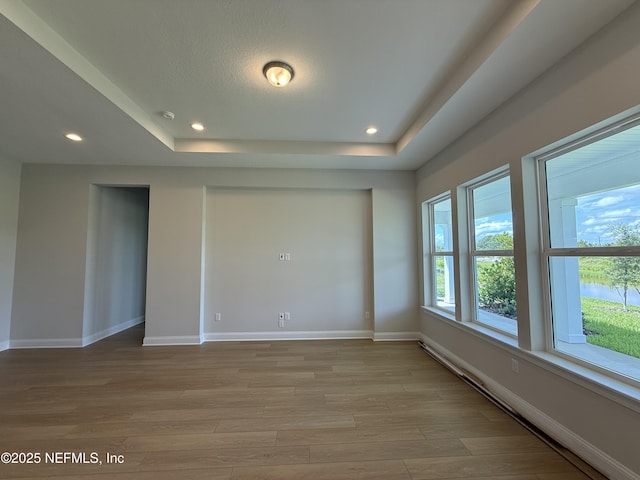294 Lamego Ln, Saint Augustine, FL 32095 - empty room with a raised ceiling, light wood-style flooring, a baseboard radiator, and recessed lighting