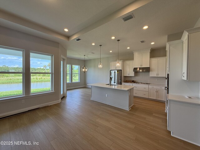 294 Lamego Ln, Saint Augustine, FL 32095 - kitchen featuring under cabinet range hood, light countertops, white cabinetry, light wood finished floors, and recessed lighting