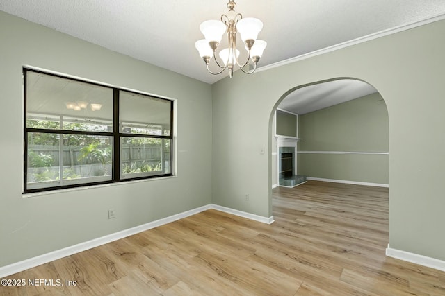 7552 Pottsburg Landing Dr, Jacksonville, FL 32216 - spare room featuring arched walkways, baseboards, a notable chandelier, and wood finished floors