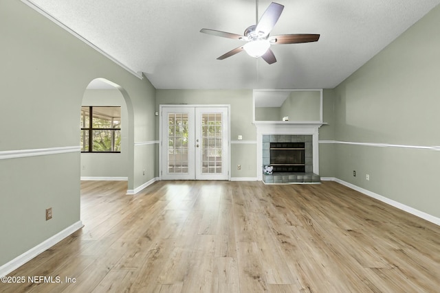 7552 Pottsburg Landing Dr, Jacksonville, FL 32216 - unfurnished living room with baseboards, wood finished floors, a ceiling fan, arched walkways, and french doors