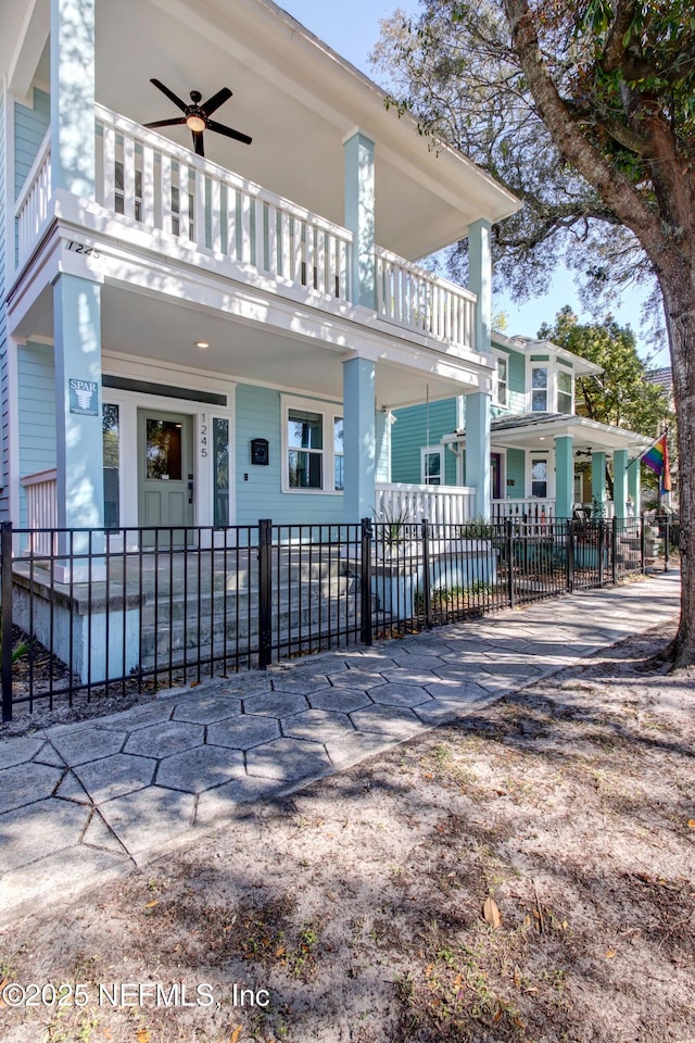 exterior space with a balcony and a fenced front yard