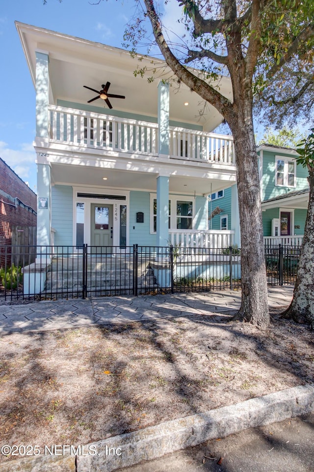 view of front of property featuring a balcony, a fenced front yard, and ceiling fan