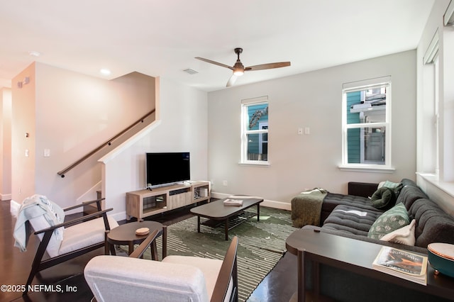 living room with wood finished floors, baseboards, stairs, and ceiling fan