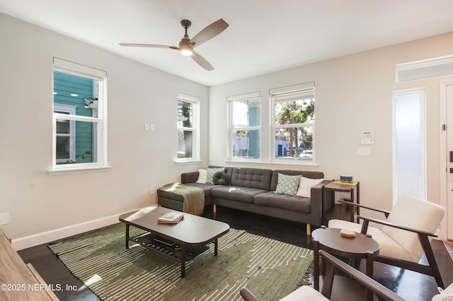 living area with wood finished floors, baseboards, and ceiling fan
