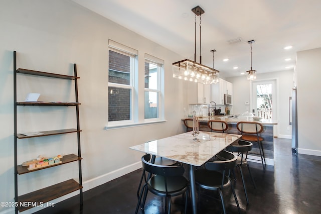 dining room with baseboards and recessed lighting
