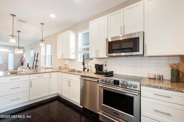 kitchen with a sink, backsplash, appliances with stainless steel finishes, visible vents, and white cabinets