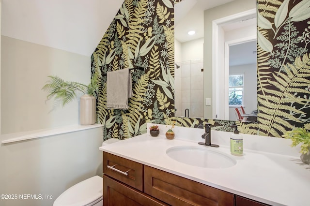 full bathroom featuring a shower stall, toilet, and vanity