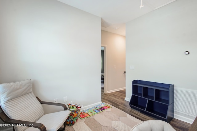 sitting room with baseboards and wood finished floors