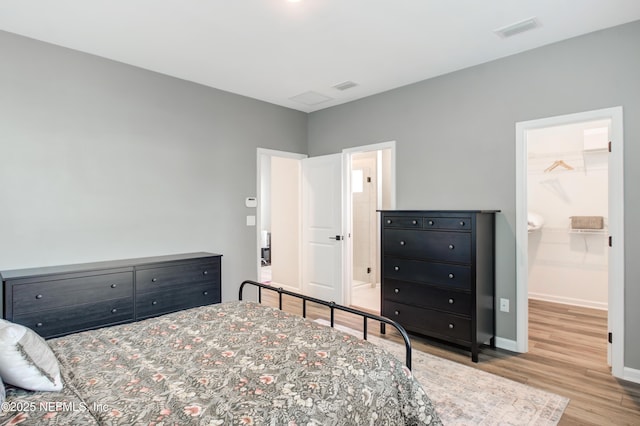 bedroom featuring baseboards, visible vents, and wood finished floors