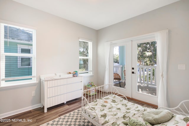 bedroom with radiator, baseboards, access to outside, and wood finished floors