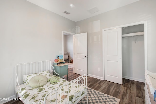 bedroom with baseboards, visible vents, a closet, and dark wood finished floors