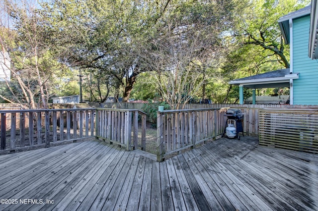 wooden deck with a fenced backyard