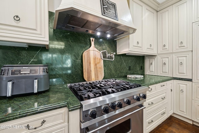 6260 Highlands Ct, Ponte Vedra Beach, FL 32082 - kitchen with high end stove, wall chimney exhaust hood, backsplash, and dark stone counters