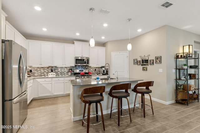 75586 Pondside Ln, Yulee, FL 32097 - kitchen with white cabinets, stainless steel appliances, tasteful backsplash, and visible vents