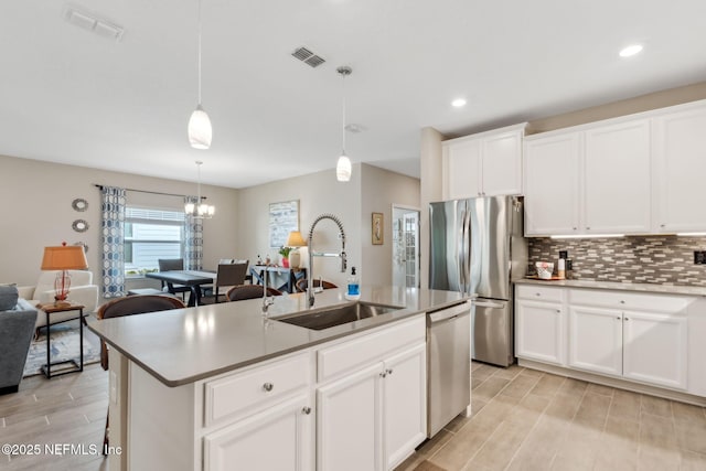 75586 Pondside Ln, Yulee, FL 32097 - kitchen featuring visible vents, a kitchen island with sink, appliances with stainless steel finishes, a sink, and backsplash