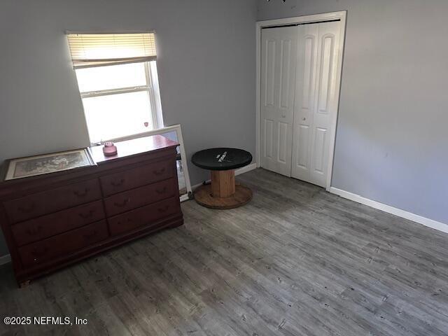 bedroom with baseboards, wood finished floors, and a closet