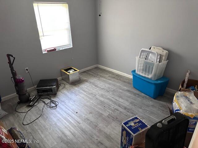 spare room featuring baseboards and wood finished floors
