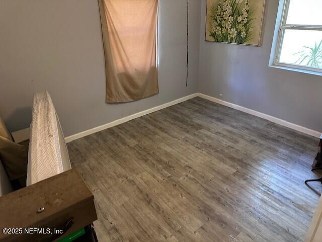 unfurnished room with wood finished floors and baseboards
